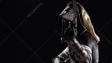 Ancient god Anubis is beckoning with his finger, low lighting