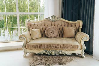 Beautiful expensive beige sofa against a white wall in an empty room