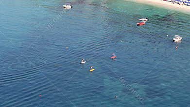 People on stand up paddle board in the sea