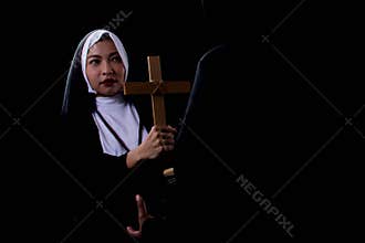 A nun is holding cross in halloween night