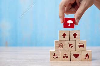 Hand holding umbrella wood block cover Insurance icon. healthcare medical, life, car, home, travel insurance concept