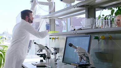 Scientist working in lab. Doctors making medical research. Laboratory tools: microscope, test tubes, equipment