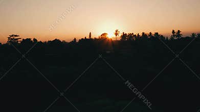 Aerial view of golden sunset above tropical island with resorts and hotels