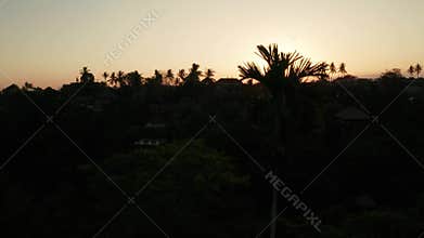Aerial view of golden sunset above tropical island with resorts and hotels