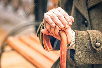 Close up of hands of elderly man leaning on cane