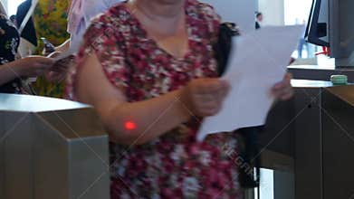 People of different ages passing electronic turnstile with barcode scanner. Media. Access control for business center