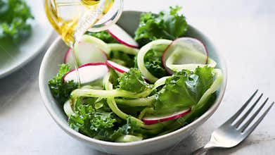 Dressing salad with olive oil