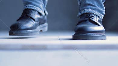 The dancer taps the rhythm with his feet.