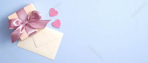 Valentine gift box with pink ribbon bow and envelope with love letter on paste blue background. Banner design for St Valentines