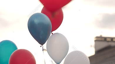 Colorful balloons are flying in the sky. People release balloons.
