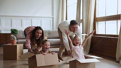 Parents and children homeowners playing with boxes on moving day