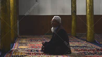 Video of an old muslim man praying in mosque