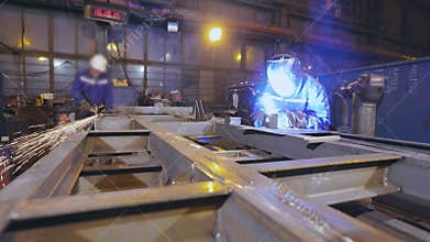 Assembly of metal parts, welding and metal stripping. Workflow in the workshop for the assembly of metal structures
