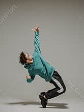Boy dancing contemporary dance in studio. Acrobatic dancer.