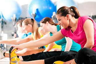 People in gym warming up stretching