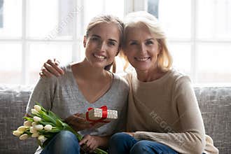 Happy senior mom and adult daughter celebrating birthday together