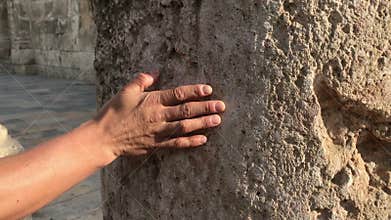 Man traveller, male hand touching ancient ruins at archeological museum history concept