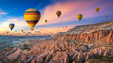 Hot air balloons and Red valley at sunset in Goreme, Cappadocia in Turkey.