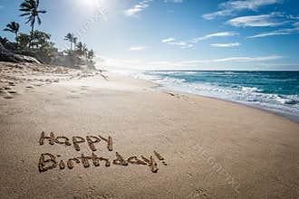 Happy Birthday written in the sand