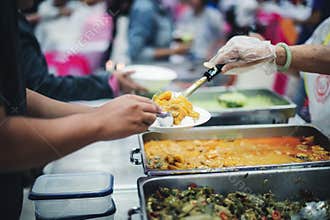 The poor reach out to receive donated food: Homeless people receive free charity food