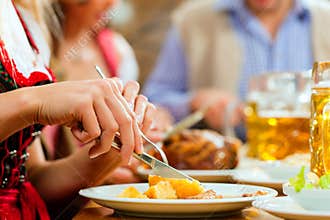 People eating roast pork in Bavarian restaurant