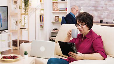 Zoom in shot of elderly age woman using tablet