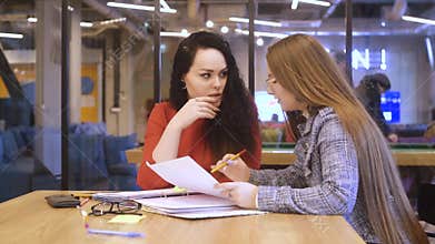 A student helps another student with homework, explains the lesson. Teacher of a foreign language. Office workers discuss contract