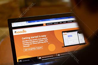 New York, USA - 9 April 2020: Moodle website on laptop screen close up. Man using service on display, blurry background