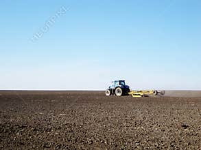 Plowed field by tractor in brown soil on open countryside nature