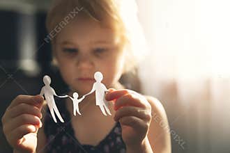 Little girl with paper family in hands. concept of divorce, custody and child abuse