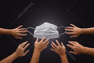 Mask with many hands try to grab or capture, shortage or surging high demand of respiratory mask to protect from Coronavirus,