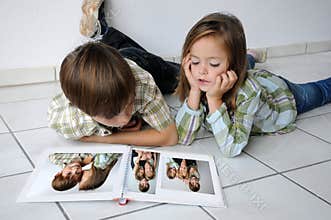 Siblings pass the time and look at photo albums