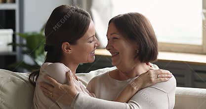 Affectionate young woman cuddling bonding middle aged mature mother.