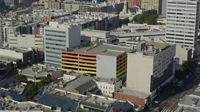 Aerial: birds eye view of downtown Los Angeles street with cars, traffic, tram and tiltup to skyline at beautiful daylight