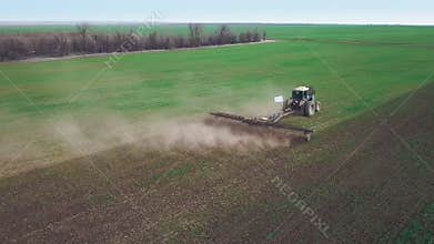 Aerial view of a powerful energy-saturated tractor with a large hook force, performing tillage for sowing winter crops