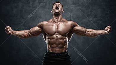 Muscular man showing muscles on wall background. Strong male naked torso abs