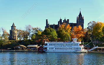 Alexandria Bay, New York, U.S.A - October 24, 2019 - The view of Boldt Castle and ferry surrounded by striking fall foliage along