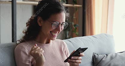 Euphoric young attractive woman reading sms with good news.