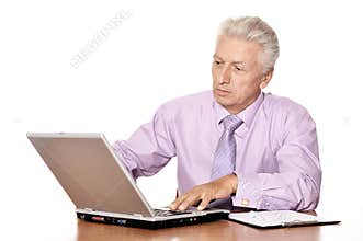 Old businessman working with laptop isolated on white background