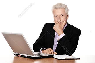 Old businessman in headphones working with laptop isolated on white background
