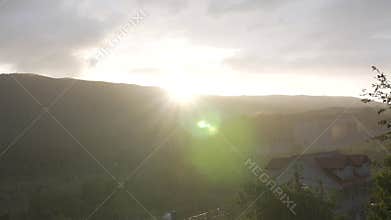 The sun sets over the mountain and it rains blindly over the eco village