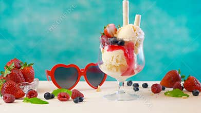 Making gourmet berry and vanilla ice cream sundae