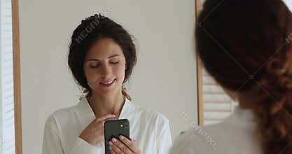 Portrait 35s woman reflected in mirror using smartphone check email