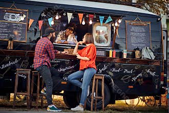 Hipster couple ordering from food truck; Urban lifestyle concept