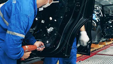 Auto mechanic, car factory worker assembling a car door