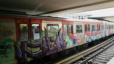 A colourful, graffiti-covered train of the subway system of Athens, Greece, arriving at the station