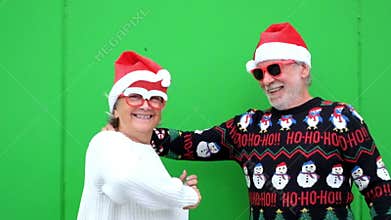 Couple of two happy seniors and mature people enjoying celebrating and dancing together wearing winter and christmas clothes havin