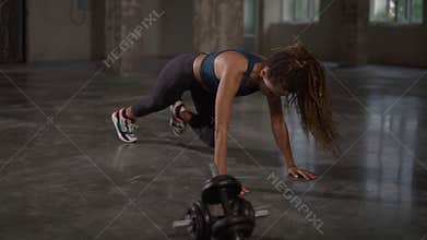 Young sporty stylish woman train her body workout her muscles indoor at empty studio. Athletic beautiful styylish woman