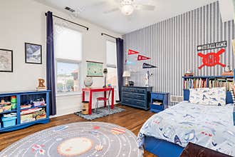 A large boys, baseball themed bedroom.