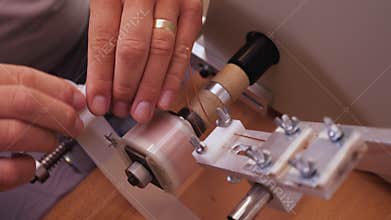 Hands making electronic component - reeling wire on a terminal